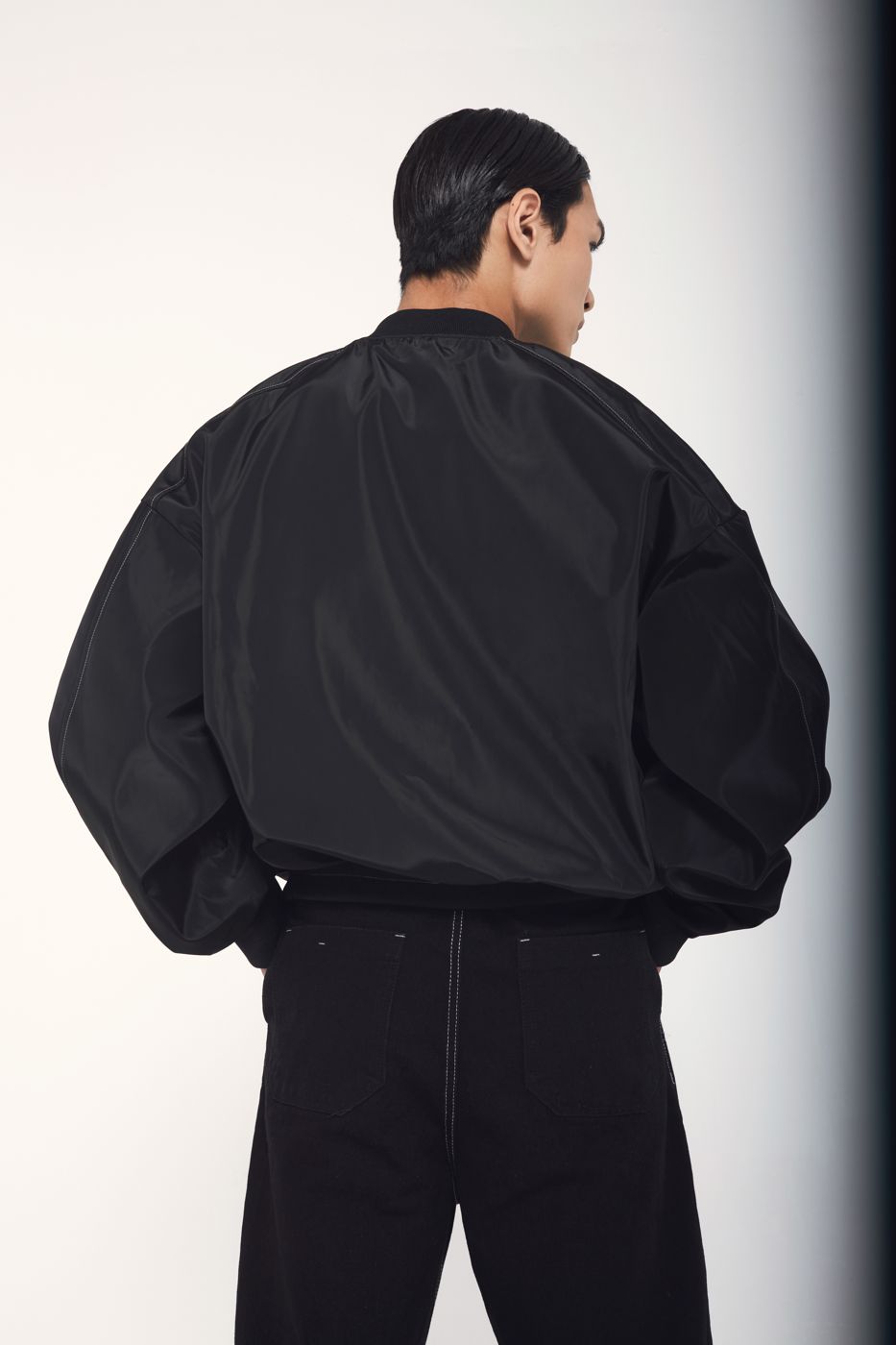 Black bomber from behind, light falling off